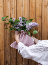 Tablier de jardinage en lin rose poudré Confetti Mill, mise en scène lifestyle, ambiance naturelle et consciente