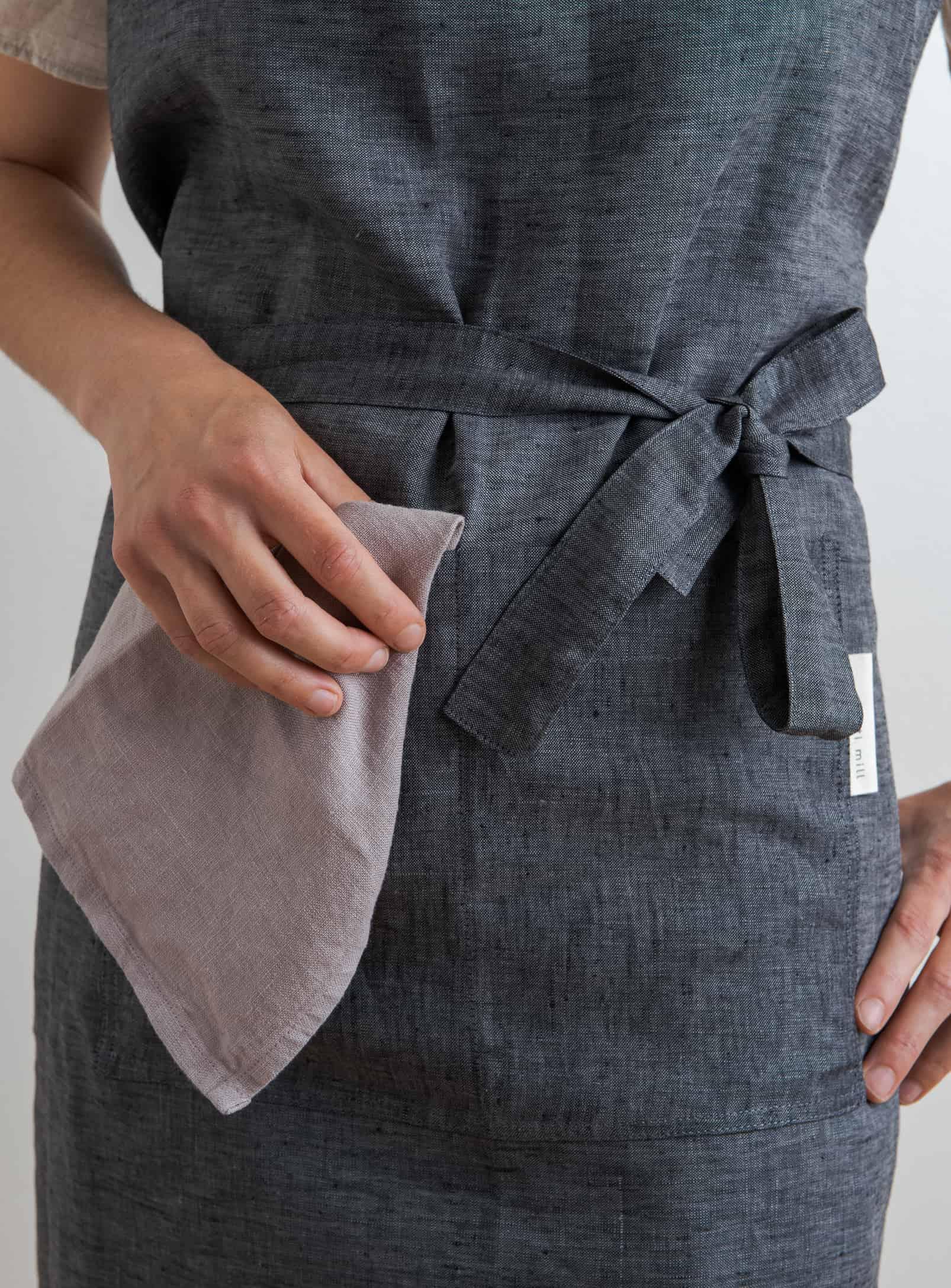 Tablier en lin ajustable anthracite Confetti Mill, détail poche avant et texture du lin naturel